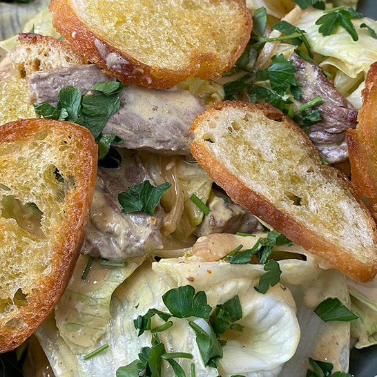Salatbowl mit Rumpsteak auf geröstetem Brot mit Senfdressing